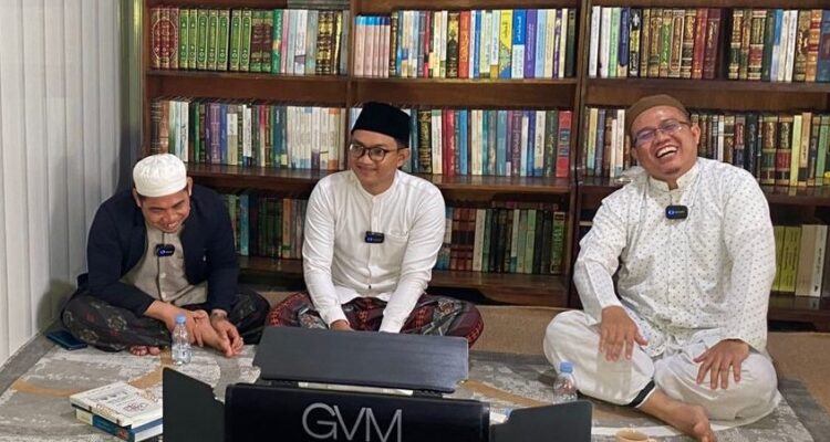 Ustadz Ahmad Syuhada al-Alaby duduk di posisi paling kanan, mengenakan sarung putih, baju putih berbintik-bintik, dan kopiah haji berwarna cokelat. Ia tampak tertawa, menggambarkan kehangatan suasana saat tim UIN Antasari berkunjung ke kediamannya. Di latar belakang tampak lemari besar penyimpan sekitar 400-an kitab—koleksi pribadi yang menjadi sumber rujukan dalam berbagai karya yang dikerjakannya. Foto-dok. Istimewa