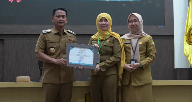 Wali Kota Banjarmasin, H. M. Yamin HR, menyerahkan penghargaan kepada salah satu perwakilan SKPD terkait pengelolaan layanan masyarakat. Foto- Dok Istimewa