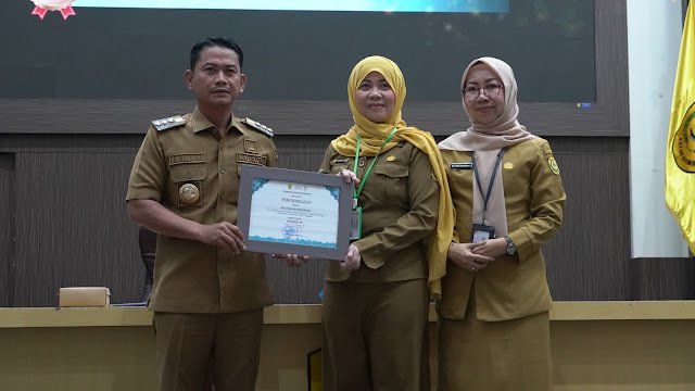 Wali Kota Banjarmasin, H. M. Yamin HR, menyerahkan penghargaan kepada salah satu perwakilan SKPD terkait pengelolaan layanan masyarakat. Foto- Dok Istimewa